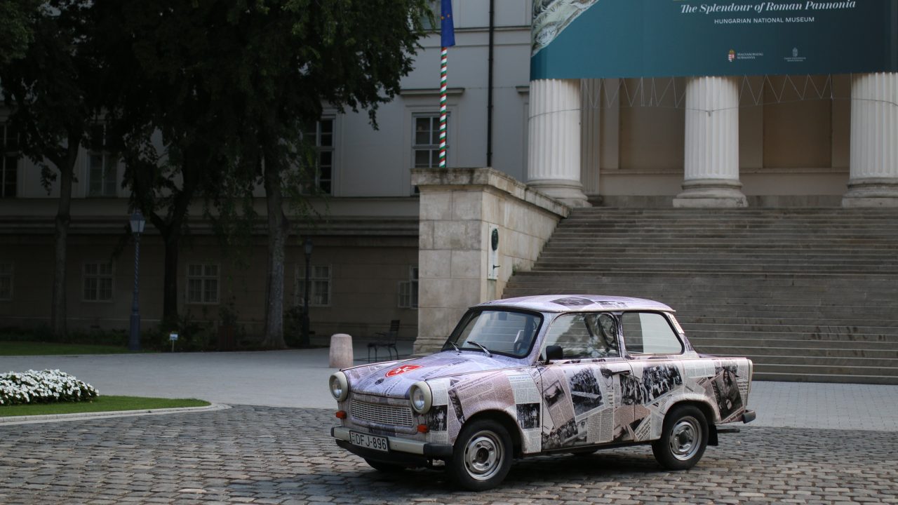 Ein Auto mit einem Zeitungspapieraufdruck steht vor dem ungarischen National Museum in Budapest.