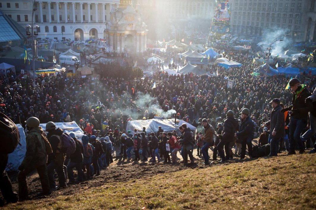 Am 09. Februar 2014 singen Ukrainer*innen die Nationalhymne auf dem Unabhängigkeitsplatz in der Hauptstadt Kiew, auf dem Maidan-Platz. Wenige Tage später eskaliert die Situation. Die Polizei stürmt das Protestlager. Bei den Auseinandersetzungen sterben mehr als 100 Zivilist*innen.