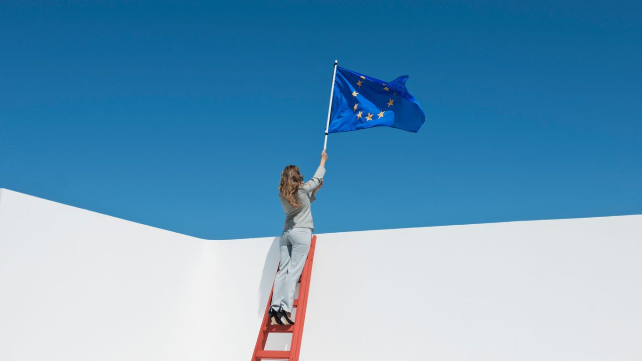 Frau hält eine EU-Flagge in die Luft